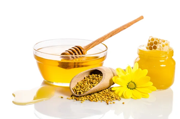 De bank van honing met honingraten, glazen kom met honing en woo — Stockfoto