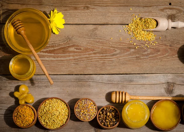 Los cuencos con miel y polen sobre una mesa de madera —  Fotos de Stock