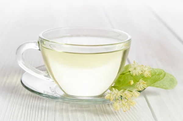 Glas kopje thee met linden op witte houten tafel — Stockfoto