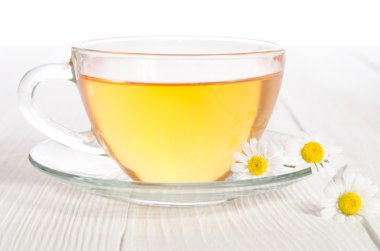 Ahşap masa üzerinde tıbbi papatya çayı fincan