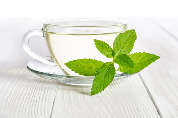 Glas kopje thee met munt op de witte houten tafel — Stockfoto