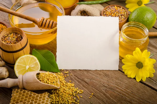 Продукты пчеловодства с лимонами на деревянном столе с пустой машиной — стоковое фото