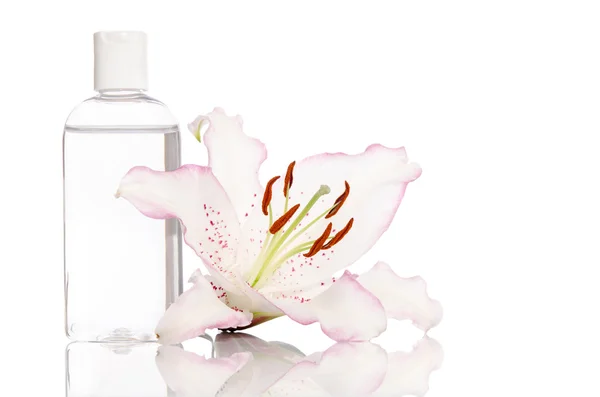 Tonik do pielęgnacji skóry z lilii kwiat na białym tle — Zdjęcie stockowe