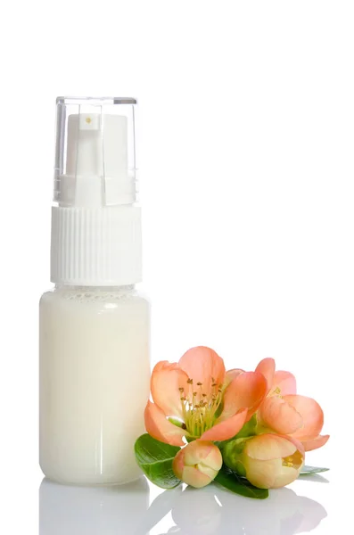 Flaske med lotion og blomster isolert på hvitt – stockfoto