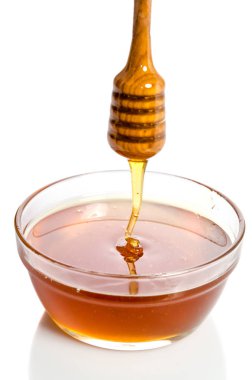 Bir ahşap bal ayı cam kase isolat damlayan bal