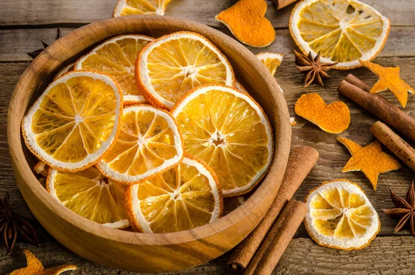 Спеції і повна миска з сухим апельсином на дерев'яному фоні — стокове фото
