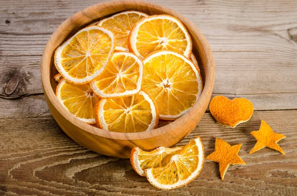 Bowl with dry orange on wooden table — Stock Photo, Image