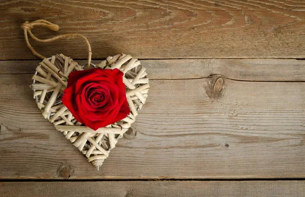 Corazón de mimbre hecho a mano con brote de rosa roja —  Fotos de Stock