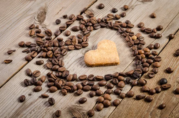 Moldura de grãos de café e biscoitos-coração dentro dele — Fotografia de Stock