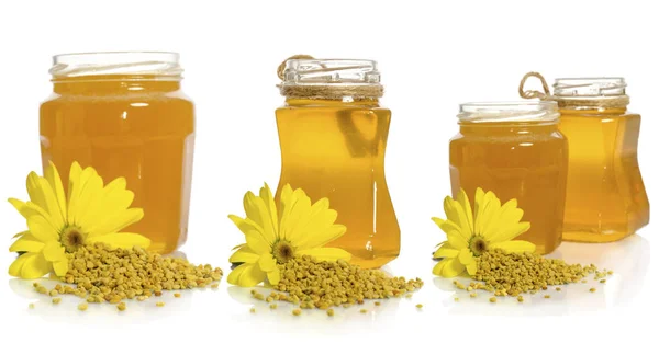 Das Honigglas in der Nähe von Pollenhaufen und Blüten — Stockfoto