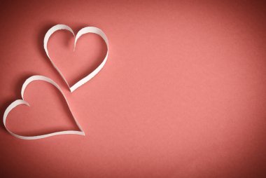 beyaz kırmızı bir arka plan üzerinde yalan kağıttan kalpleri