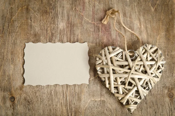 Wicker heart handmade lying on a wooden base — Stock Photo, Image
