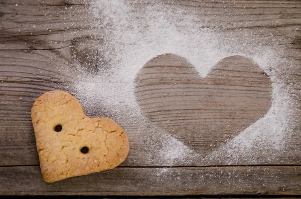 Marca em forma de coração com açúcar em pó e biscoito — Fotografia de Stock