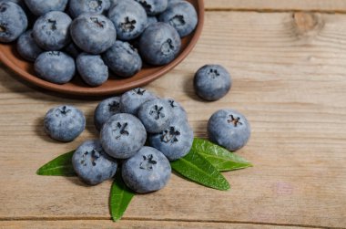 ahşap arka plan üzerine bir tabak içinde yaban mersini