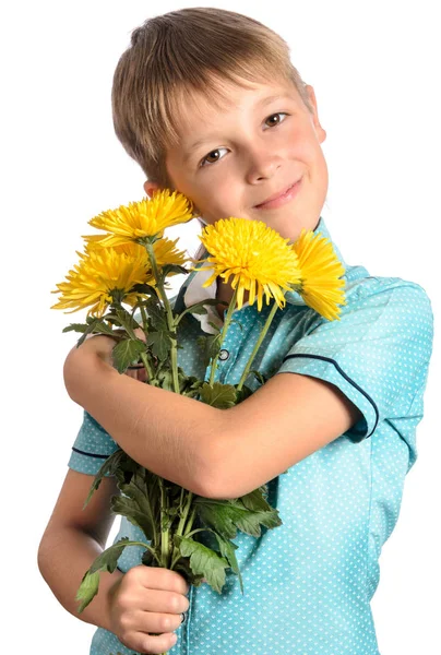 Niño sosteniendo un ramo de crisantemos, sonriendo y mirando — Foto de Stock