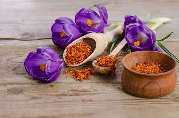 Flores de croco e colher com sofá na mesa de madeira — Fotografia de Stock