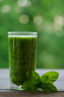 Ahşap masa üzerinde sağlıklı yaz içeceği nane ile yeşil smoothie
