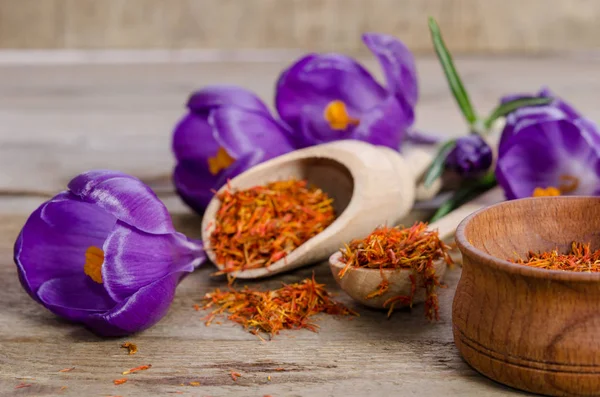 Flores de croco e colher com sofá na mesa de madeira — Fotografia de Stock