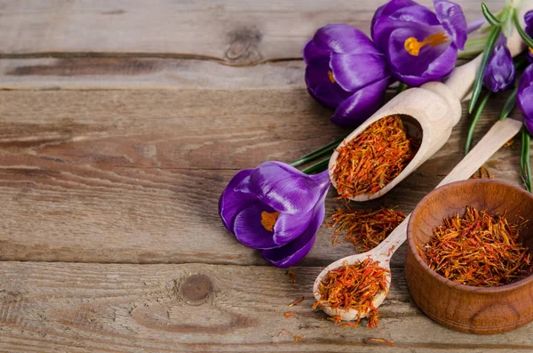 Flores de croco e colher com sofá na mesa de madeira — Fotografia de Stock