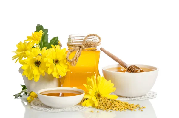 Fleurs jaunes et produits apicoles (miel, pollen) isolés sur du blanc — Photo