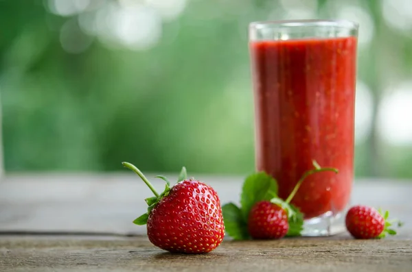 Fresas y batido de cóctel de fresa en una mesa de madera —  Fotos de Stock