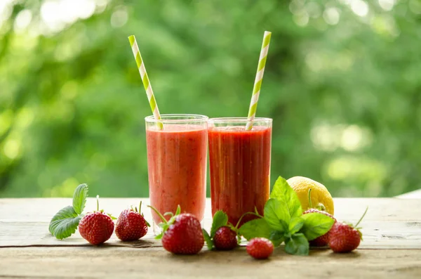 Lemon, mint leaves, strawberries and cocktails smoothie on a woo — Stock Photo, Image