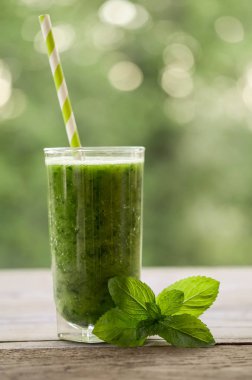  Yeşil smoothie ahşap bir masa ve nane yaprakları ile cam