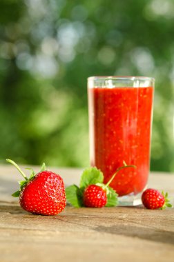  çilek ve ahşap bir masa üzerinde çilek kokteyli smoothie