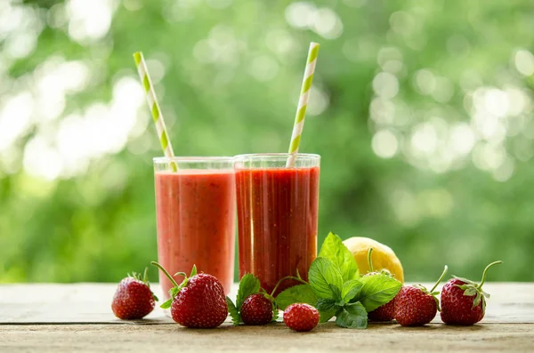 Lemon, mint leaves, strawberries and cocktails smoothie on a woo — Stock Photo, Image