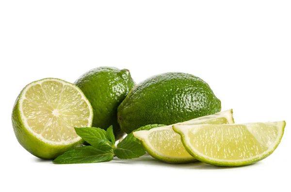 Grön mynta, två limefrukterna och två skivor av en saftig lime — Stockfoto