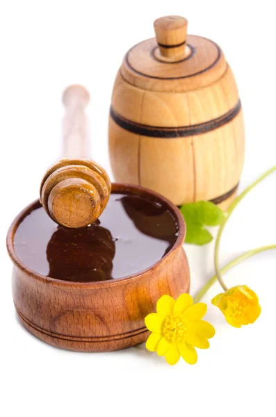 Miel en el cuenco de madera y barril de madera con flores amarillas — Foto de Stock