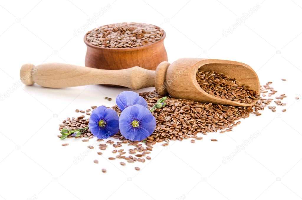 Flax seeds in the wooden bowl, wooden scoop and beauty flowers