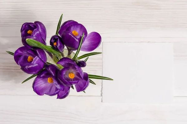 Buquê de flores de croco em vaso na mesa de madeira branca — Fotografia de Stock