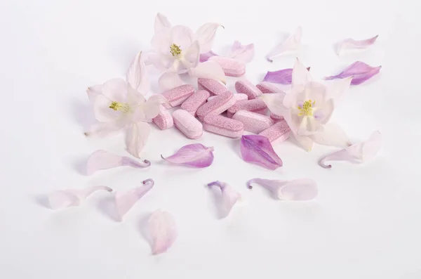 花とテーブルの上の花びらと代替薬の錠剤 — ストック写真
