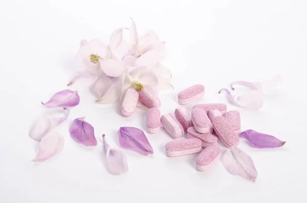 Medicina alternativa compresse con fiori e petali sul tavolo — Foto Stock