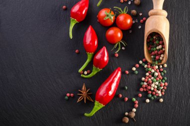 Domates ve biber siyah bir arka plan ile farklı baharatlar