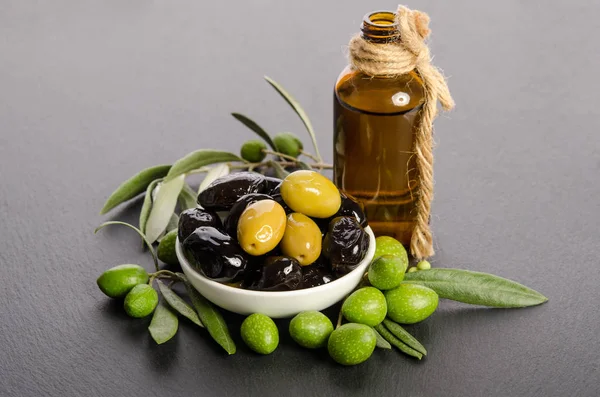 Black and green  olives  mixed in the  porcelain bowl and Virgin olive oil