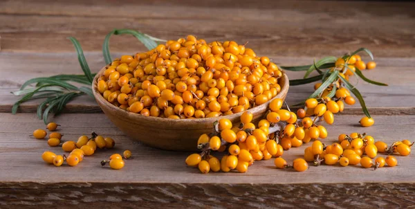 Sea buckthorn in the bowls  and  on wooden table — Stock Photo, Image