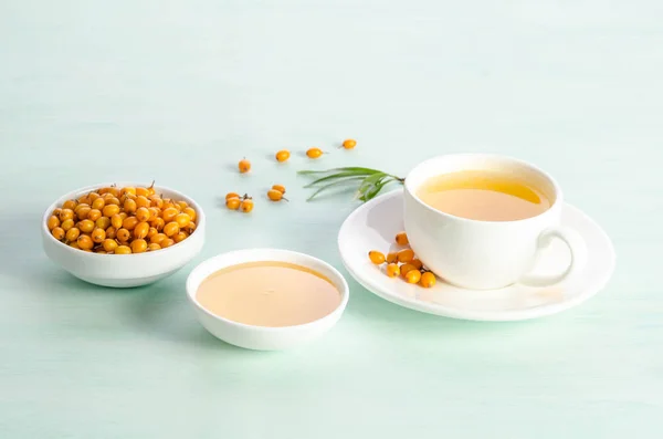 Sea buckthorn in porcelain bowl, honey and cup of  tea with Sea buckthorn — Stock Photo, Image