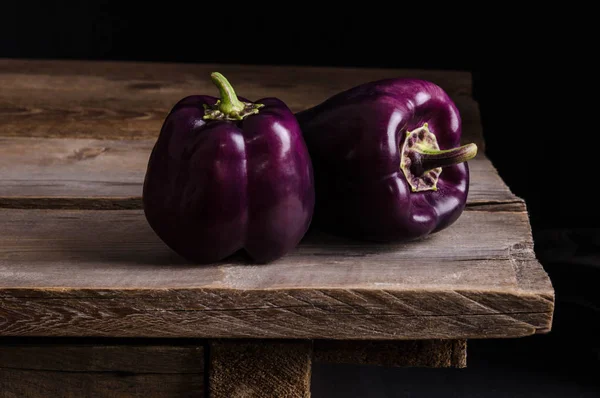 Légumes frais. Poivrons violet foncé avec des feuilles de basilic — Photo