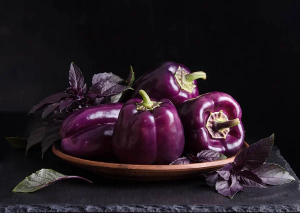 新鲜蔬菜深紫色的辣椒在板块与罗勒叶 — 图库照片