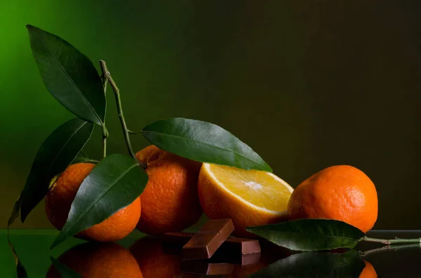 Laranjas e Chocolate em fundo verde escuro — Fotografia de Stock