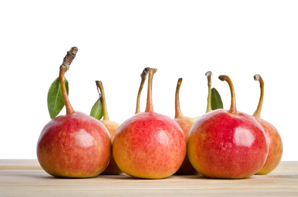 Small pears and leaves in a grouping on wooden table — Stock Photo, Image