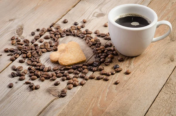 A chávena de café e Frame- coração de grãos de café e dois biscoitos-coração — Fotografia de Stock