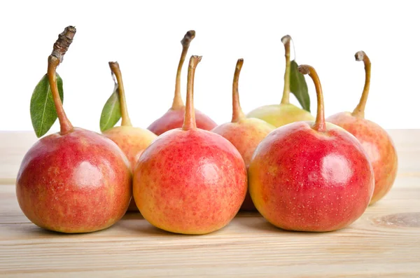 Small pears and leaves in a grouping on wooden table — Stock Photo, Image