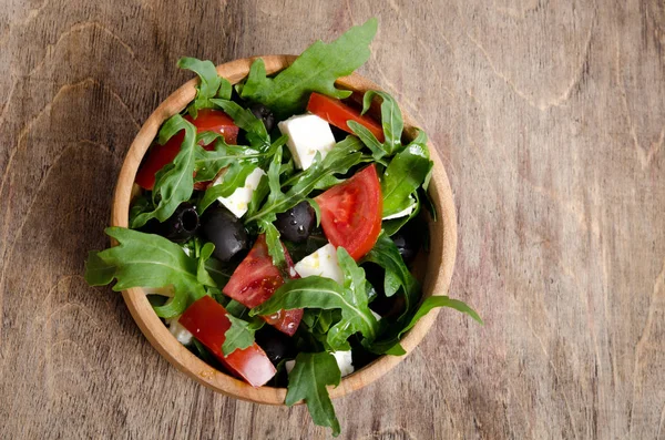 Sallad med tomater och Oliver på trä bakgrund — Stockfoto