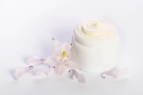 Симпатичный цветок и банка натурального крема для тела изолированы на белом — стоковое фото
