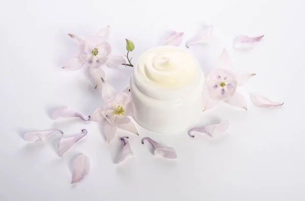 Lindas flores y pétalos y un frasco de crema corporal natural —  Fotos de Stock