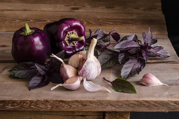 Donker paarse paprika met blaadjes basilicum en knoflook — Stockfoto