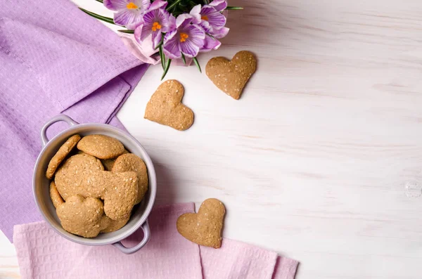 Lilac crocuses and sesame dry cookies in the form of heart on a — Stock Photo, Image